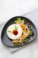 Delicious stewed squid with rice in a dark dish.