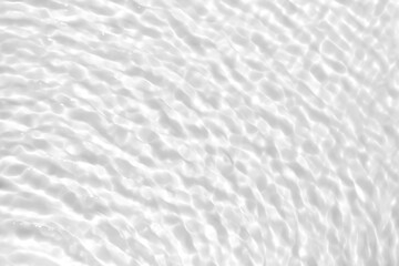 Photo of rippled calm water shadow. Subtle white texture of light-shadow pattern of sunlight reflection from rippled water surface. Beautiful natural wallpaper. White-grey water waves marbling.