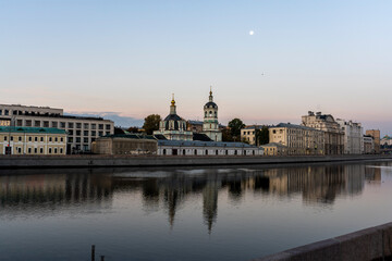 river embankment of a large metropolis at dawn with reflections in the river