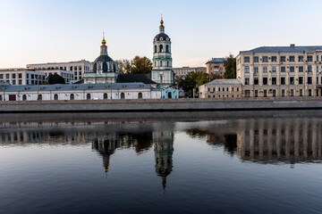 river embankment of a large metropolis at dawn with reflections in the river