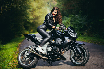 Plakat Biker sexy woman sitting on motorcycle. Outdoor lifestyle portrait