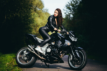 Naklejka na ściany i meble Biker sexy woman sitting on motorcycle. Outdoor lifestyle portrait