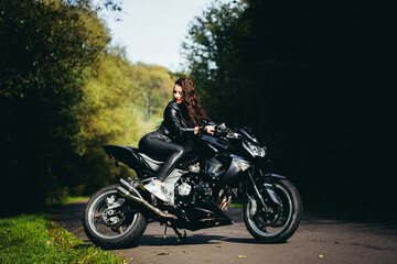 Obraz na płótnie Canvas Biker sexy woman sitting on motorcycle. Outdoor lifestyle portrait