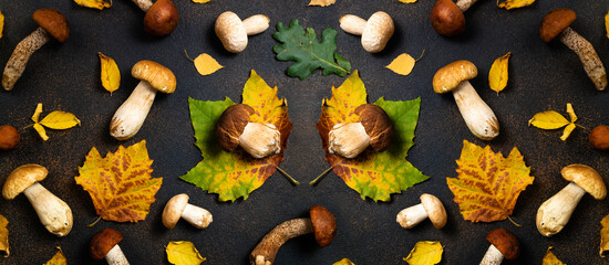 Autumn background with mushrooms and leaves. Mushrooms boletus, orange-cap boletus mushrooms and autumn leaves on brown table. Mushrooms pattern, flat lay, top view