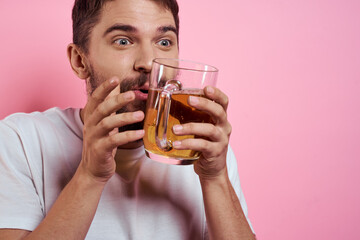 Bearded man with a mug of beer On a pink background fun emotions cropped view of a white T-shirt drunk