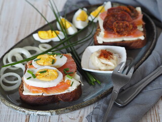 Open sandwiches with dark rye bread with salmon, cheese, eggs and green onions.Healthy natural food. View from above.