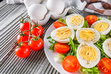 salad with boiled chicken eggs and cherry tomatoes on a wooden rustic background
