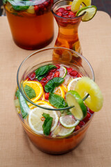Refreshing lemonade with fresh fruit orange lemon cherry and mint leaves. Delicious non-alcoholic fruit cocktail in a jug