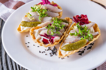 delicious snack tartlets on rustic wooden background