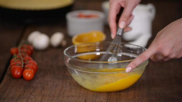Close up woman hand beat eggs in kitchen.