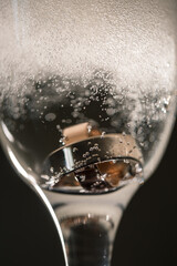 Gold precious wedding rings in a glass of sparkling champagne