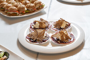 Luxurious catering table. Croutons with cheese and jam, decorated with seeds.