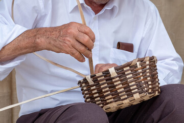 Old senior man hand working crafts hand made basket