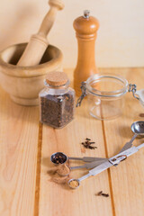 Measuring spoons and other kitchen utensils with spices, with neutral textures and colors against wooden background