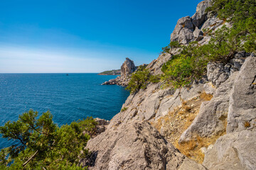 Panoramic seascape, calm azure sea and bright sun. View of the black sea coast of Crimea, Cape. Copy space. The concept of calm, silence and unity with nature