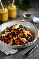 Black risotto with cuttlefish ink, chicken, chorizo sausages and vegetables.