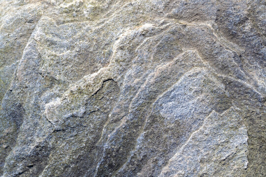 Uneven, rough, irregular granite stone surface. Natural textured relief grey background. Top view.