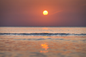 Obraz premium Spacious cave next to Baltic sea glowing in sunset colors. Beach sands and sea in colorful sunset.