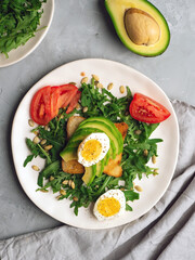 Healthy avocado toasts for breakfast or lunch with bread, arugula, sliced avocado, tomato and pumpkin seeds. Clean eating. Top view.