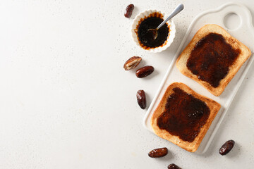 Fresh toasts with dates jam without sugar on white table. View from above. Space for text.