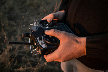 The remote control of a radio-controlled model aircraft in men's hands.