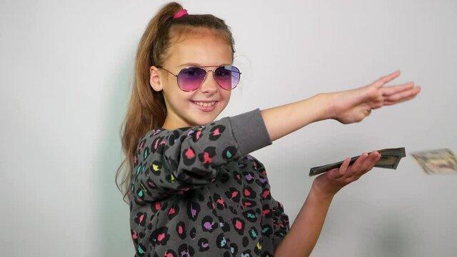 Funny girl throws money on white background. Slow motion