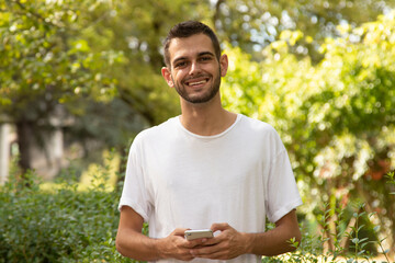 Fototapeta premium attractive young man with mobile phone outdoors