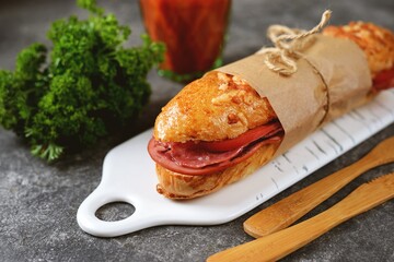 Sandwich with ham, salami and tomato.