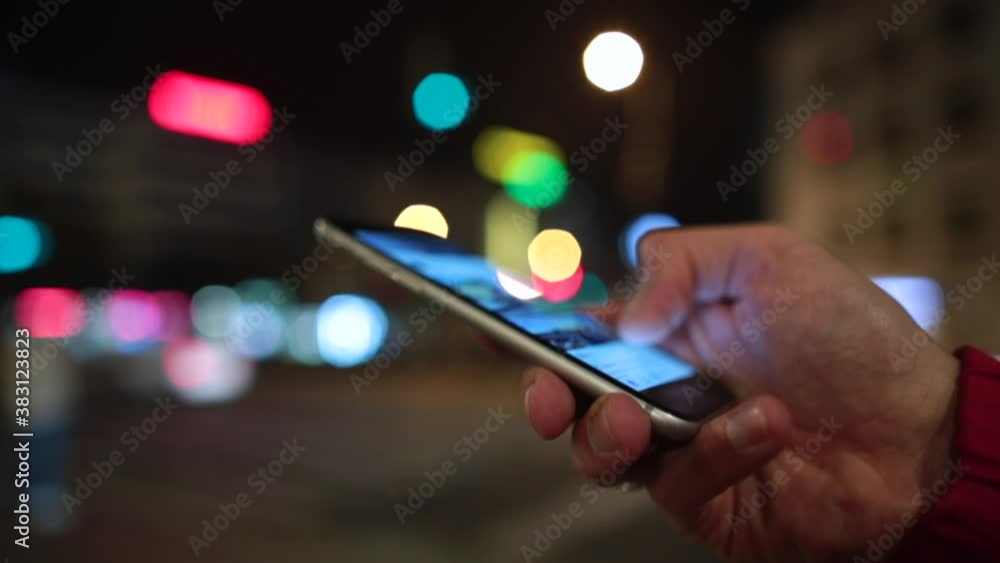 Poster close-up of a hand with a mobile phone in the evening in the city. viewing evening posts on the soci