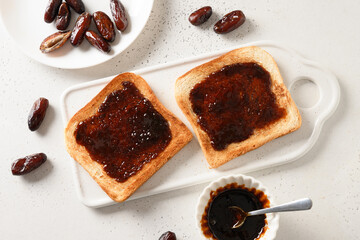 Fresh crispy toasts with dates jam without sugar on white table.  View from above.