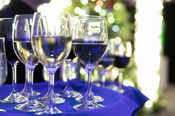 Verres à vin sur une table avec une nappe bleue lors d'un événement du temps des fêtes