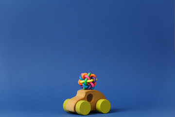 Colored rubber toy on a children wooden car.