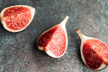 Macro photography of fresh ripe cutted figs on the textured background.