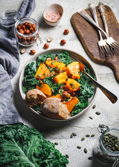 Season salad with grilled pumpkin, kale, chickpea, pepitas and nuts. Autumn vegetarian healthy recipe.