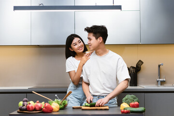 Loving Japanese Couple Cooking Preparing Dinner Embracing In Modern Kitchen