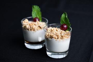 deux coupes en verre remplies de yaourt pour et de granola pour le petit déjeuner