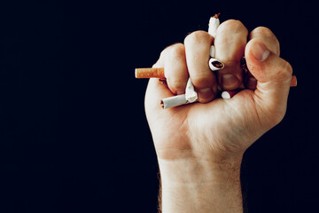 Male hand breaking cigarettes close up quitting habit