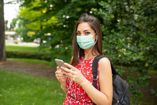 Woman listening music in a park during coronavirus pandemic