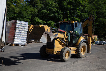 Tractor, excavator, machine is loading a truck