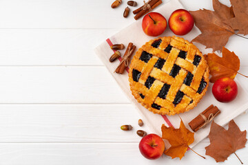 Autumn thankgiving pie on white wooden board decorated with dry leaves and cinnamon sticks © fotofabrika