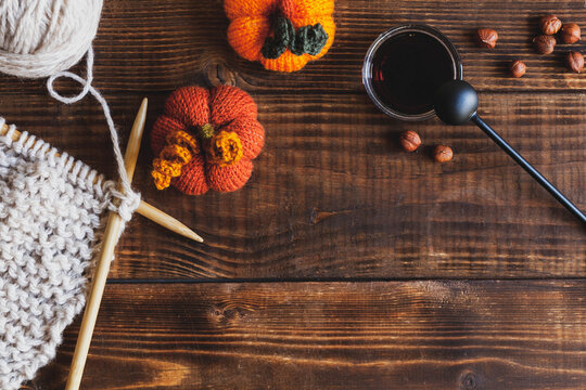 Autumn wood background with black tea and knitted accessories, top view