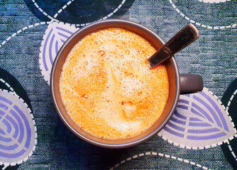 a cup of freshly brewed hot coffee with froth (americano, lurgo), on the background of an elaborately decorated surface