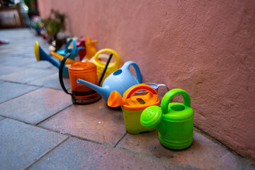 Set of multi-colored plastic watering cans for garden care