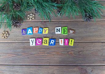 Happy new year message. Paper letters on the wooden background and new year decoration 