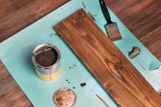 Painting lumber with wood stain coloring with paint brush