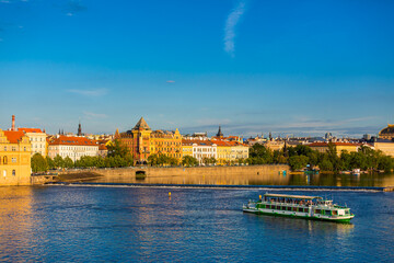Obraz premium Summer landscape of Prague view of the Ltava river on which ferries with tourists float