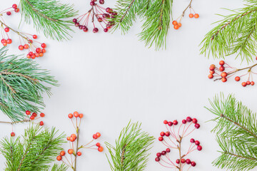 Flat lay christmas frame with pine branches and small red apples on a white background
