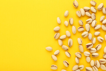 Tasty pistachios on yellow background