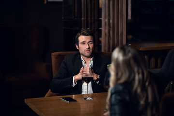 a guy and a girl came on a first date in a restaurant, sitting at the table.