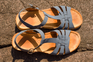 Close-up of blue sandals flat lay. Shoes on sunny day outside.